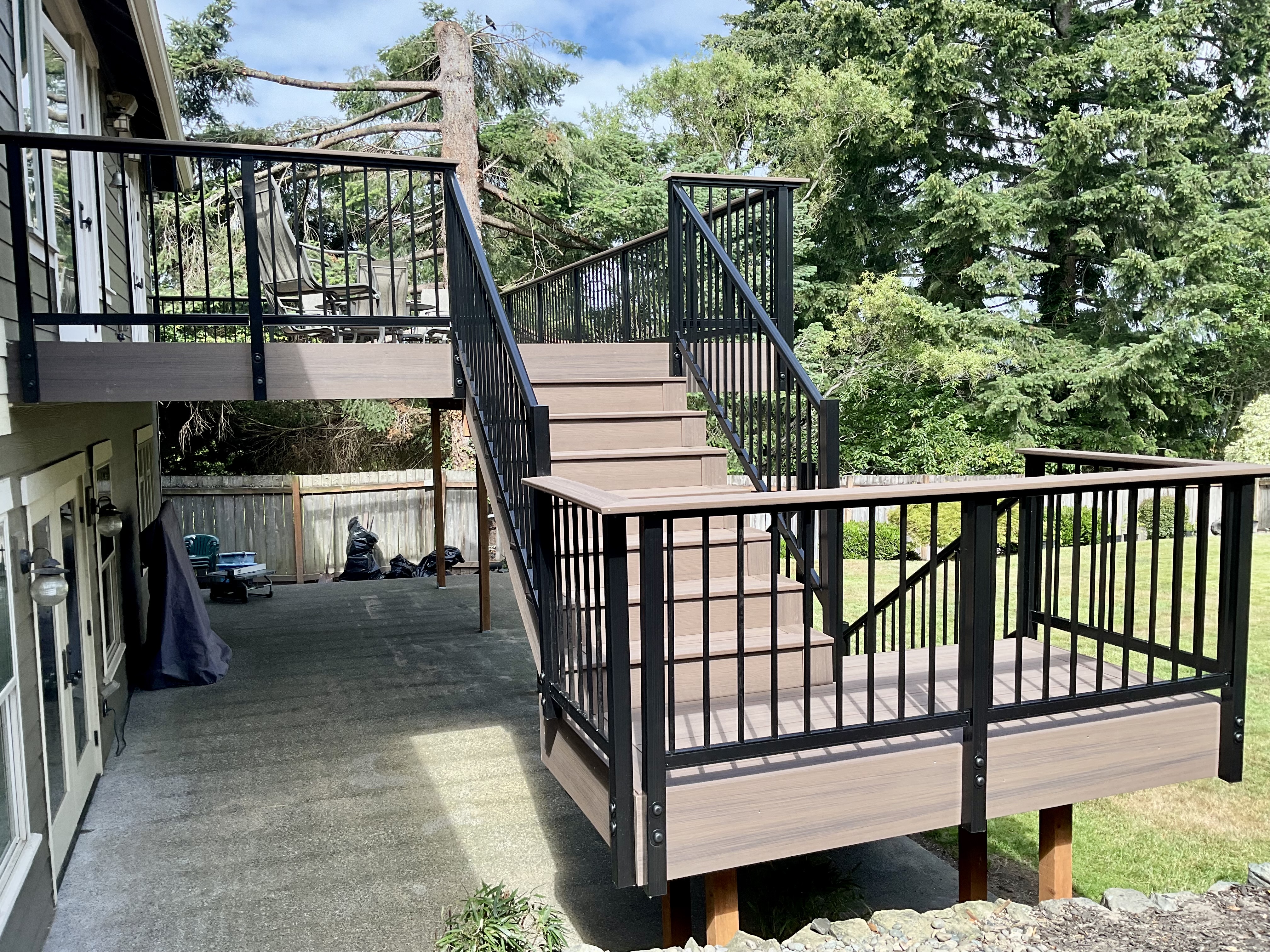 Second-story deck with cohesive black aluminum picket railing and drink rail