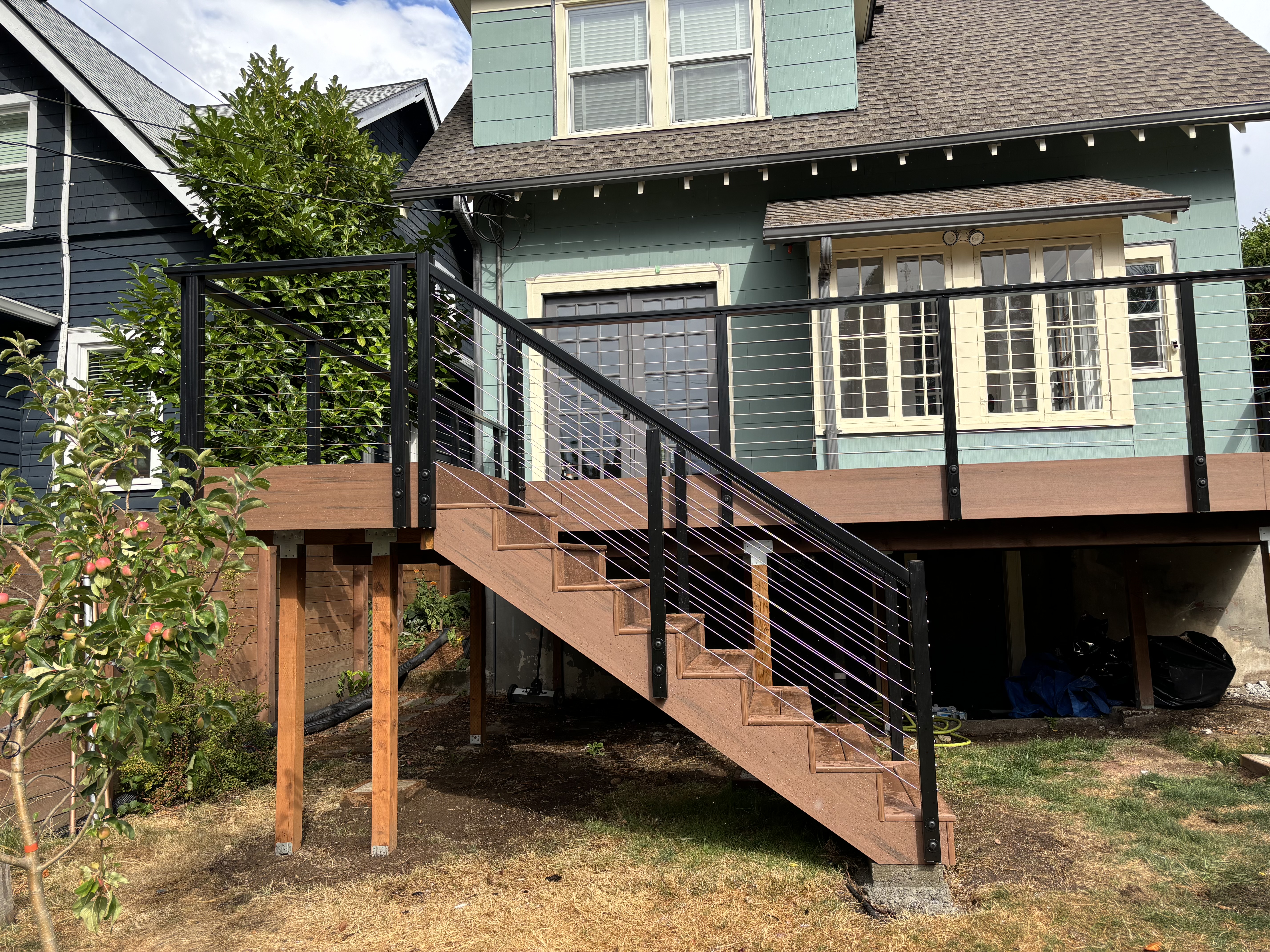 Completed TimberTech Mahogany PVC deck with black aluminum and cable railing