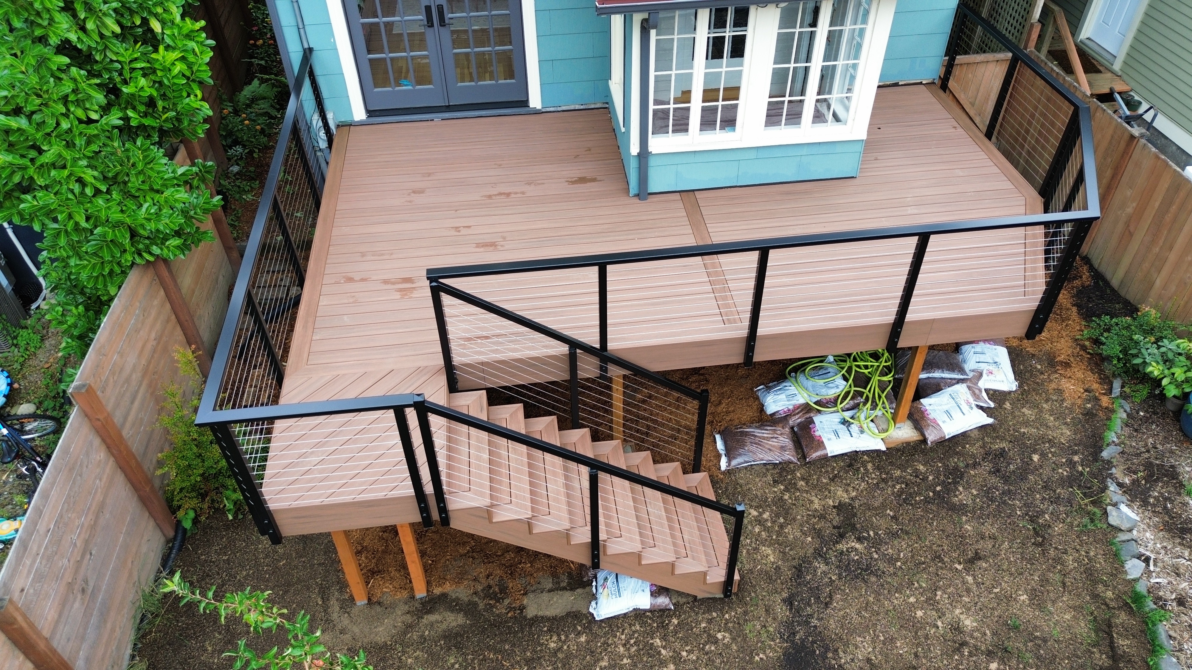 TimberTech Mahogany PVC deck with black aluminum rails and cable railing