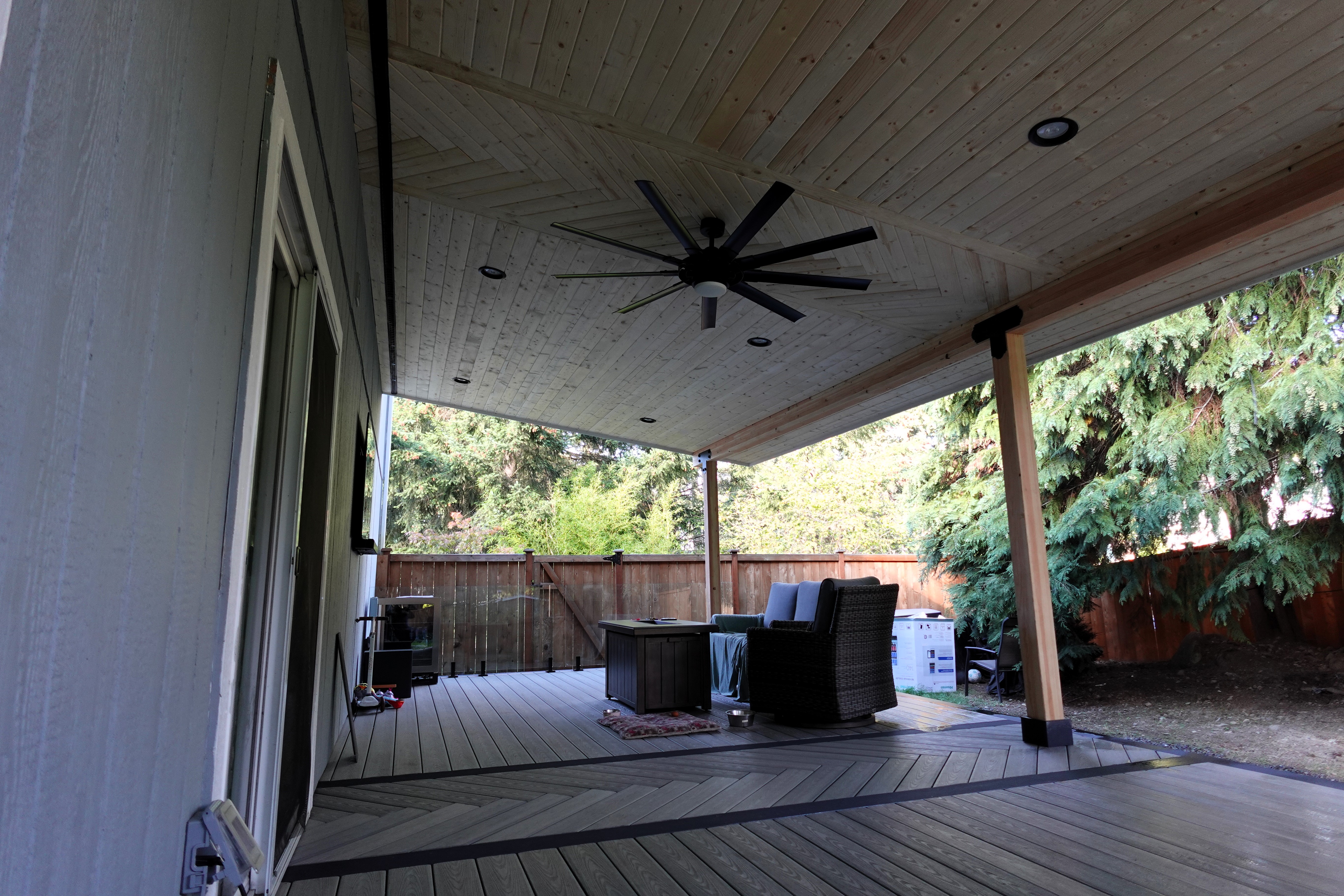 Covered outdoor living space with mounted TV and electrical setup